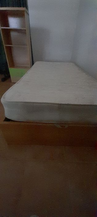 Cama solteiro com estante de apoio.