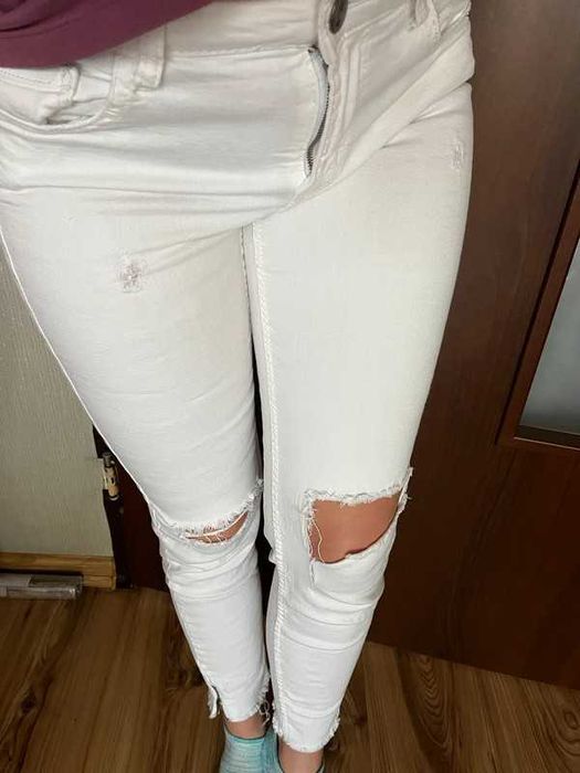 Spodnie białe z przetarciami dziurami szarpane zameczki na nogawce