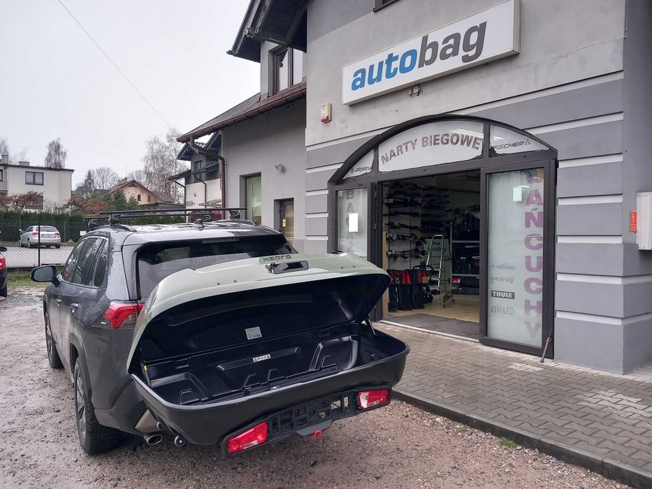 Box montowany na hak holowniczy  Hapro Boxer 420 L - mocny, solidny w kolorze oliwkowej zieleni. Odchylany - umożliwia dostęp do bagażnika samochodu