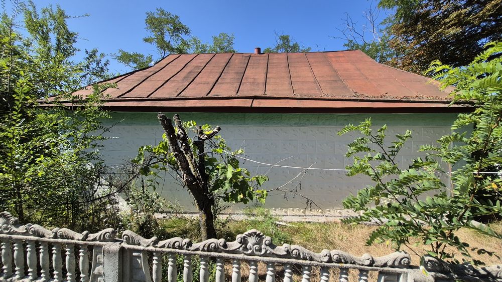 Будинок з джерельною водою на березі річки, асфальтована дорога