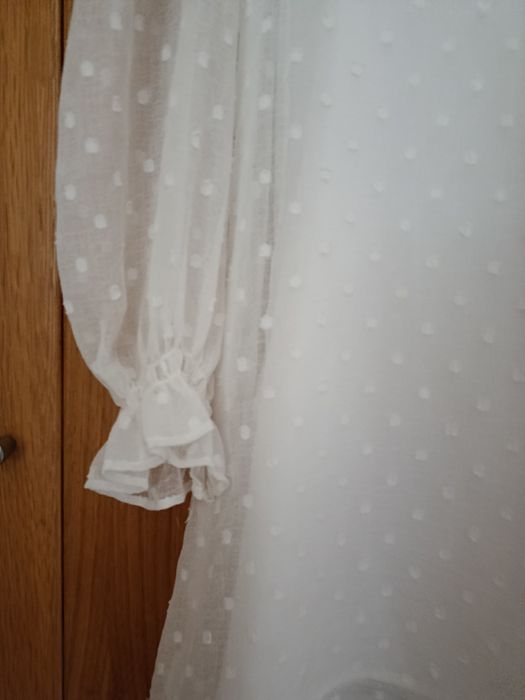 Vestido branco decote em V
Camada exterior com detalhes e folhos
Forro