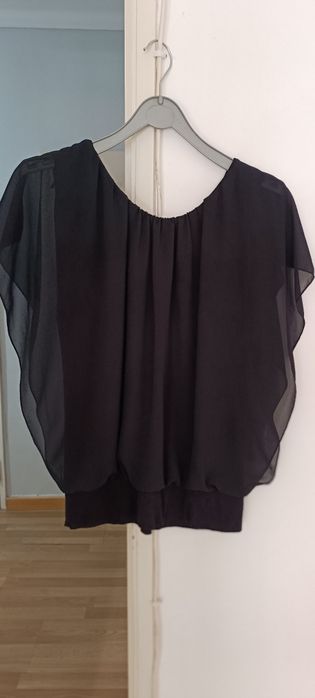 Blusa preta aberta de lado. Tem um forro em algodão por baixo.
