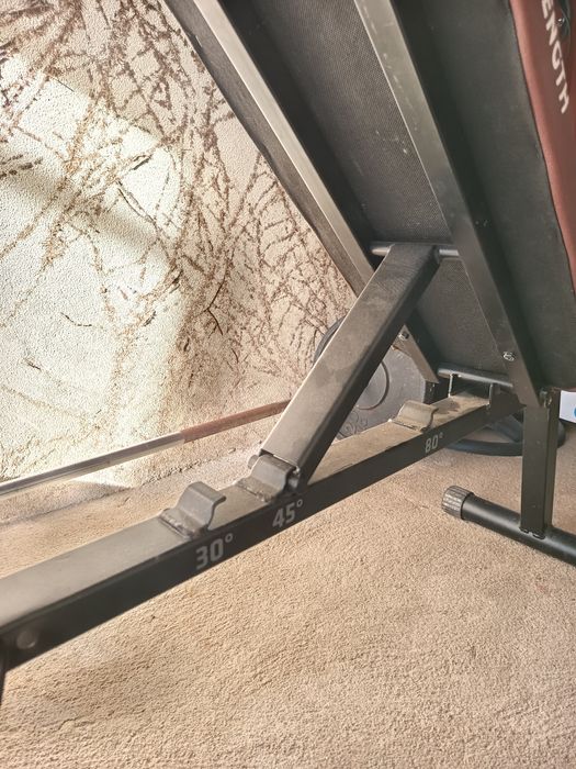 Anilhas, halteres, barras e banco de ginásio.