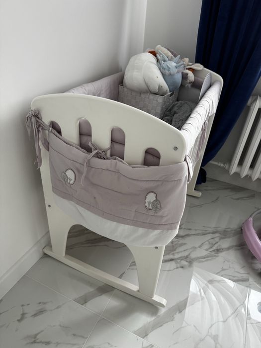 Biala drewniana kolyska z ochraniaczami i baldachimem