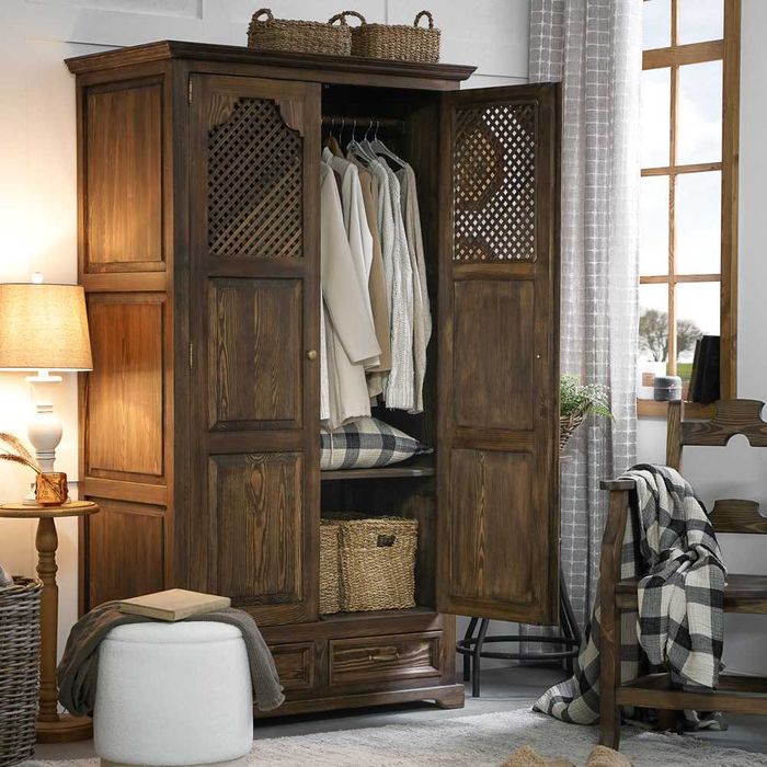 Drewniana szafa z ażurowymi drzwiami w stylu wiejskim, rustykalnym