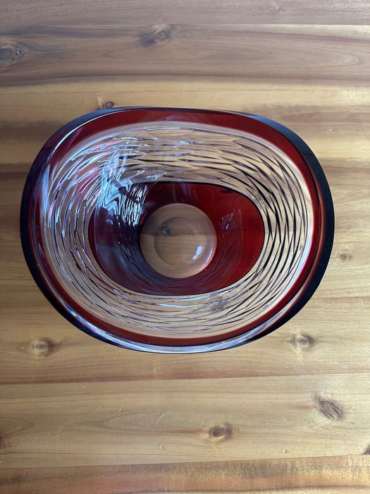 Vaso ou fruteira de cristal Bohemia em vermelho rubi, caracterizada pelo design de linhas lapidadas à mão que criam um efeito visual dinâmico