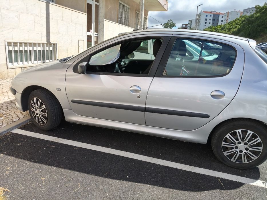 Peugeot 206 cinza 
Tem sensores de estacionamento na retaguarda 
Rádio com micro sistema mãos livres
Inspeção até 27/12/2026 sem qualquer anotação