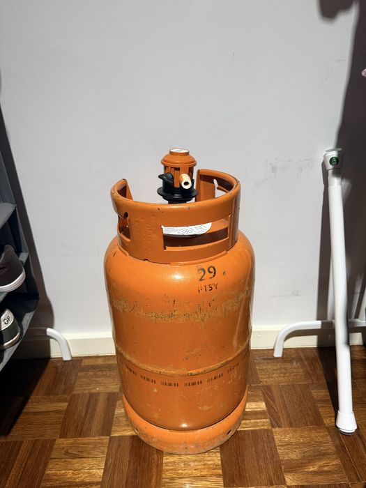 Cilindro de gás usado, com válvula. A quantidade está pela metade.
