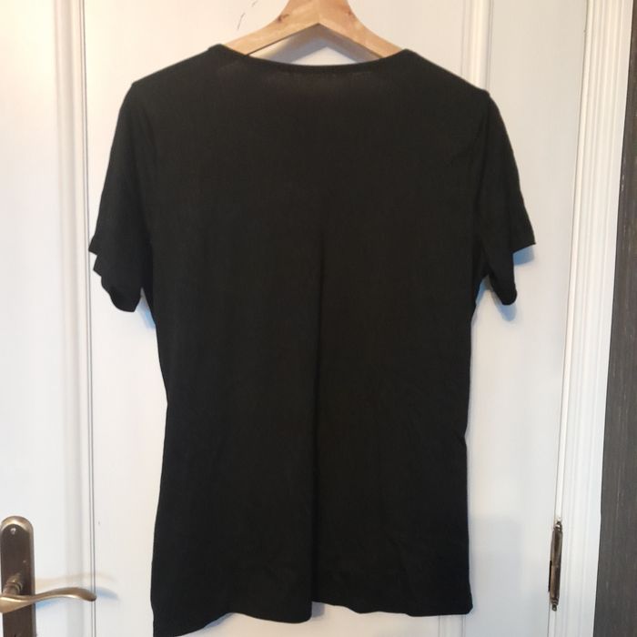 Blusa preta mangas curtas, traçada à frente na zona do cós, decote V