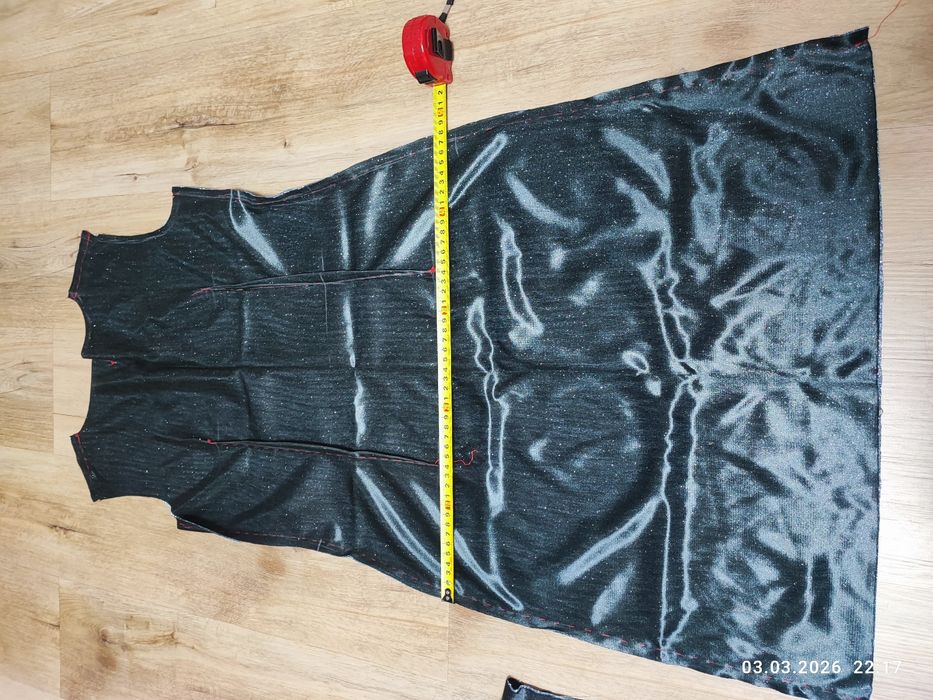 Недошита сукня з блискучої стальної тканини.