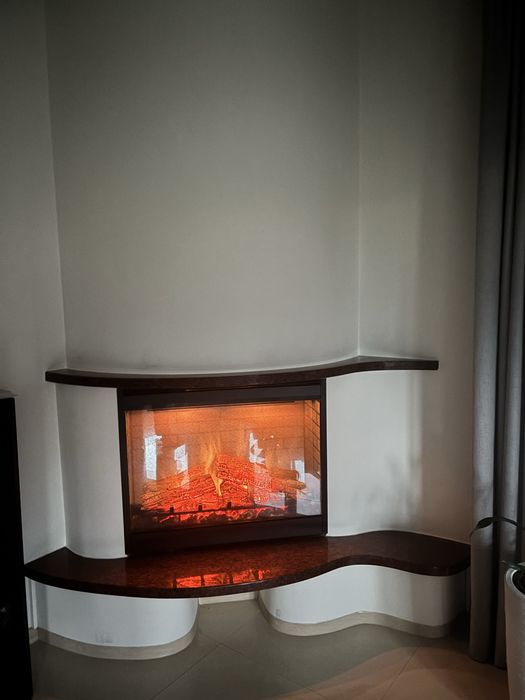 Kominek elektyryczny w zabudowie z polkami z naturalnego kamienia