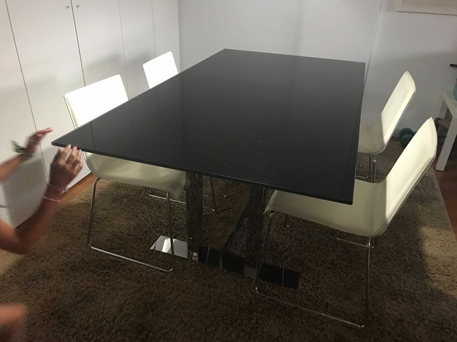 quatro cadeiras de pele branca e base em inox