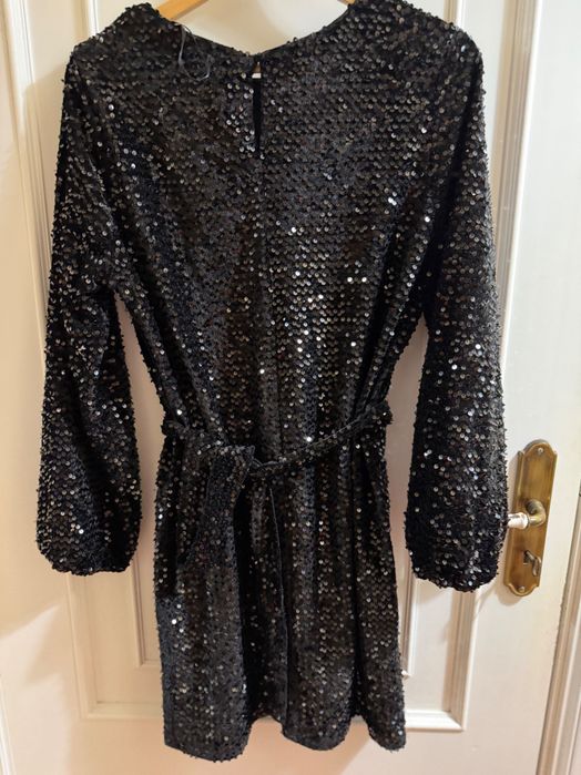 Vestido preto de lantejoulas pretas.