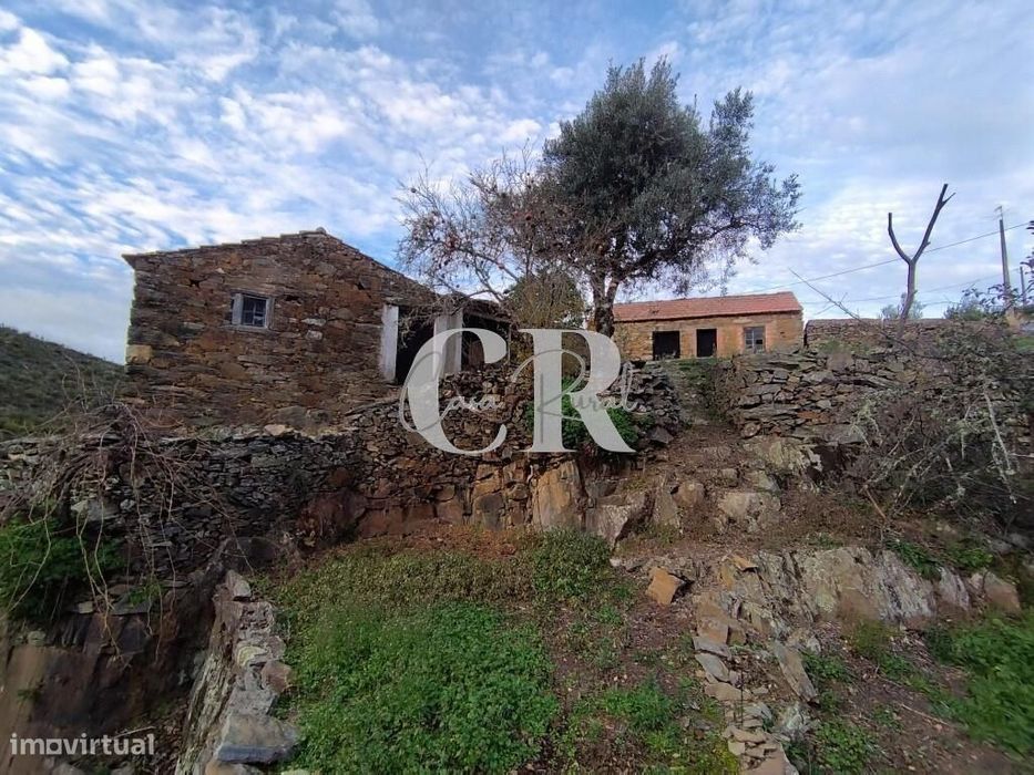 Moradias em pedra, para recuperar, a confrontar com ribeira em Oleiros — Isna, Castelo Branco