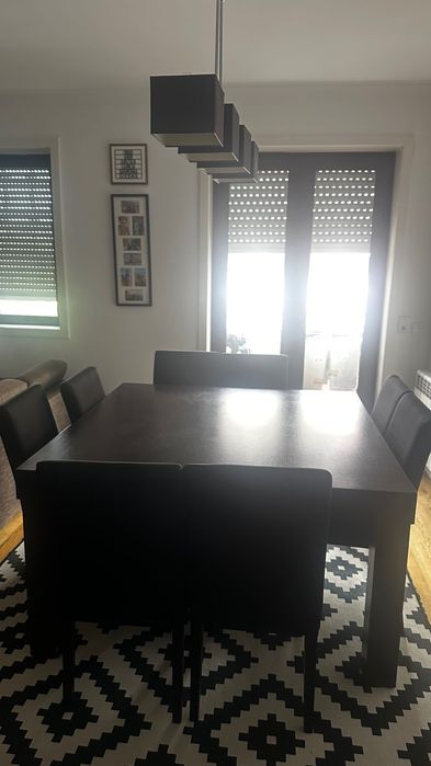 Mesa extensível castanha escura Interdesign  com 8 cadeiras cremes de pele pêssego.
