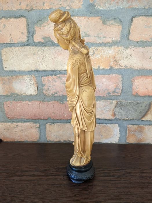 Decoração artesanal origem Ásia mulher com arranjo de flores