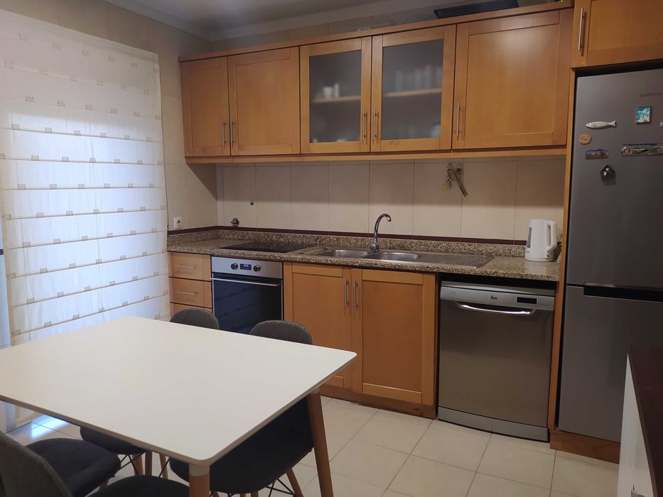 Mesa de cozinha com quatro cadeiras e um móvel igual
