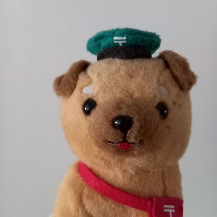 Cão de peluche carteiro