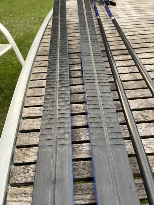 Zestaw narty biegowe, kijki, buty i pokrowiec.