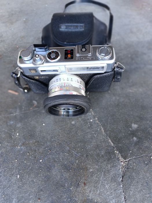 Máquina fotográfica antiga yachika um par de botas anti fogo e  outros