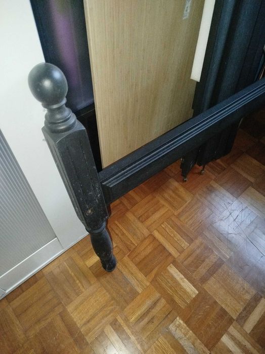 Cama de solteiro restaurada, de cor preto mate.