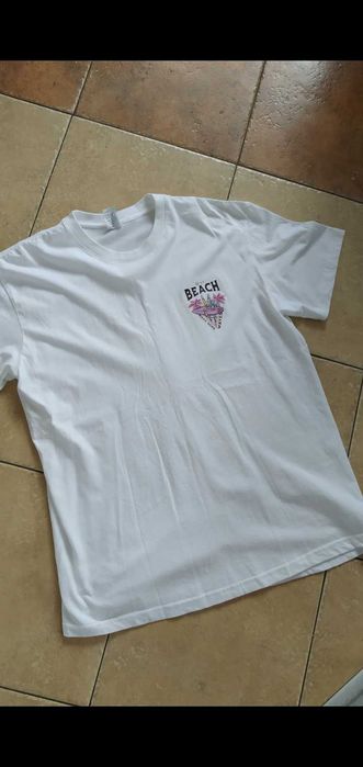 biała koszulka z napisem na plecach