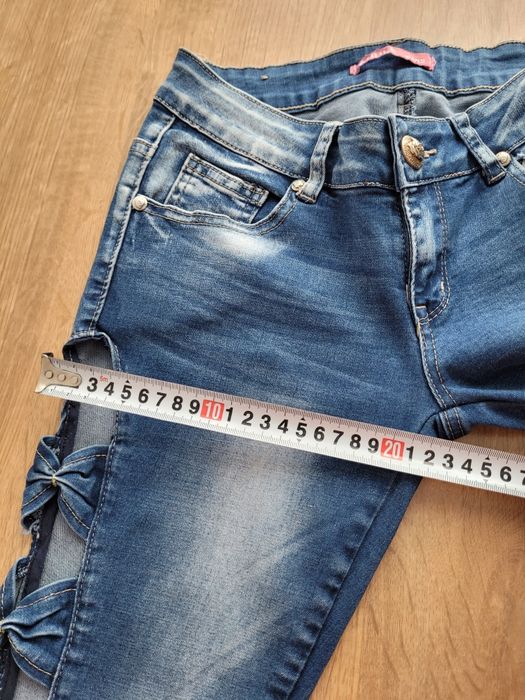 Damskie spodnie jeansowe z kokardami  po bokach