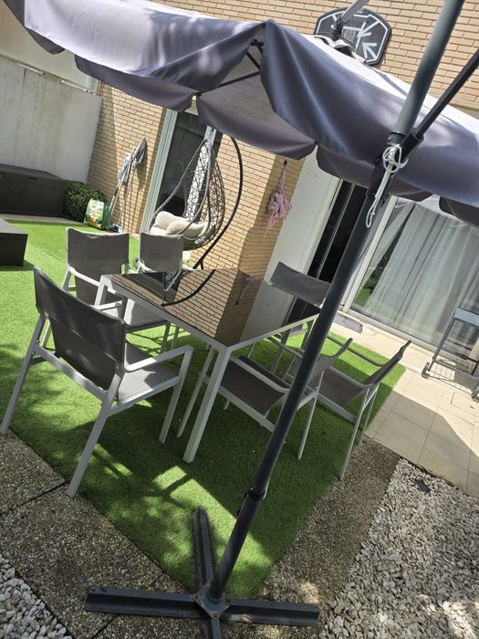 Mesa de jardim com cadeiras e guarda sol