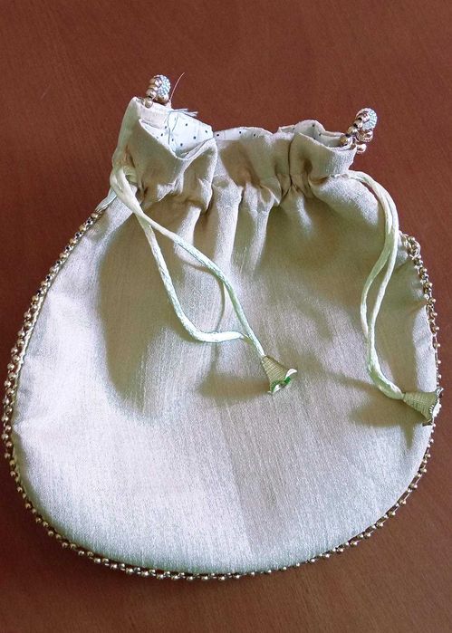 Delicada bolsa de mão branca com bordado floral dourado e coral