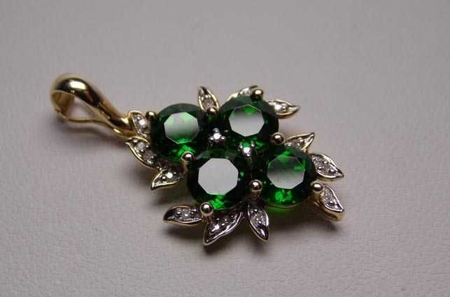 Złota zawieszka zielone diopsydy chromowe i diamenty.