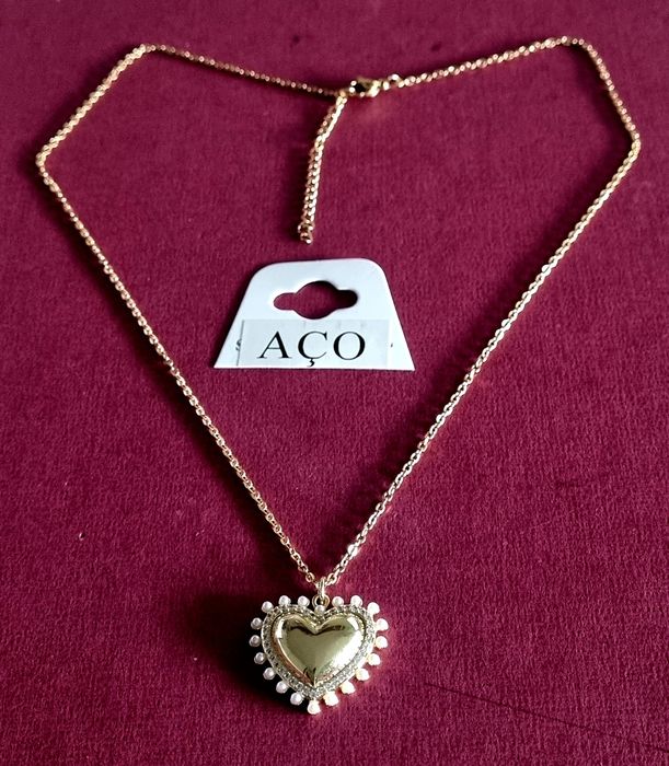 Colar dourado, em aço, com pingente formato coração rodeado de zirconias e pérolas