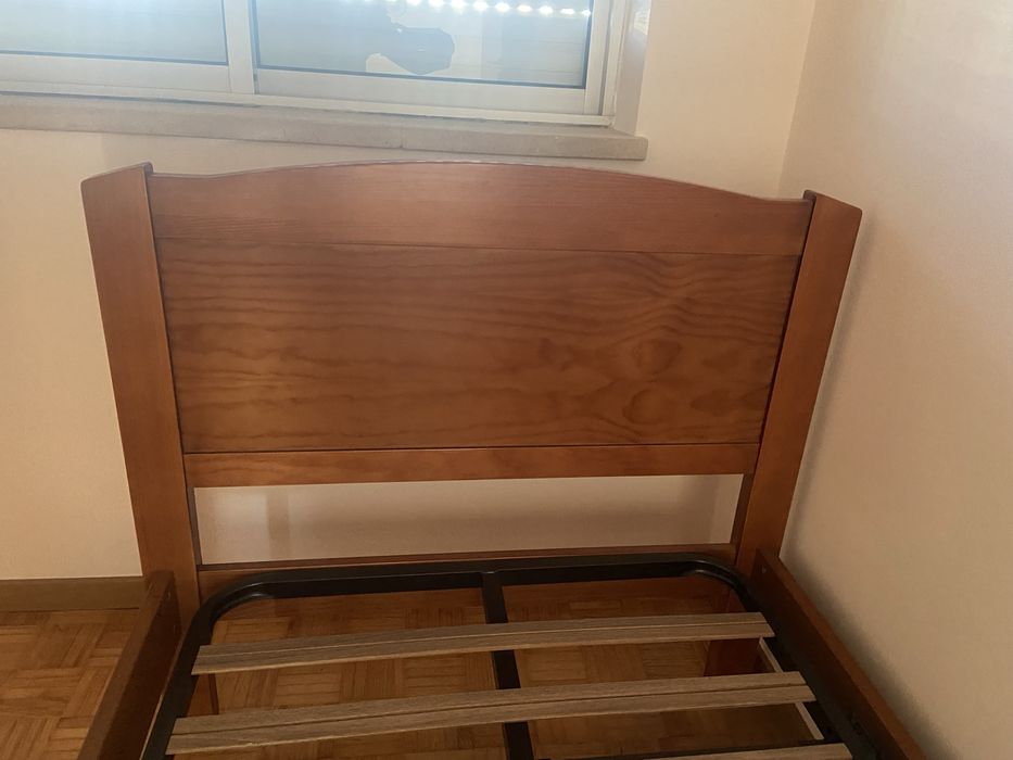 Cama individual de madeira macica e uma mesa de cabeceira