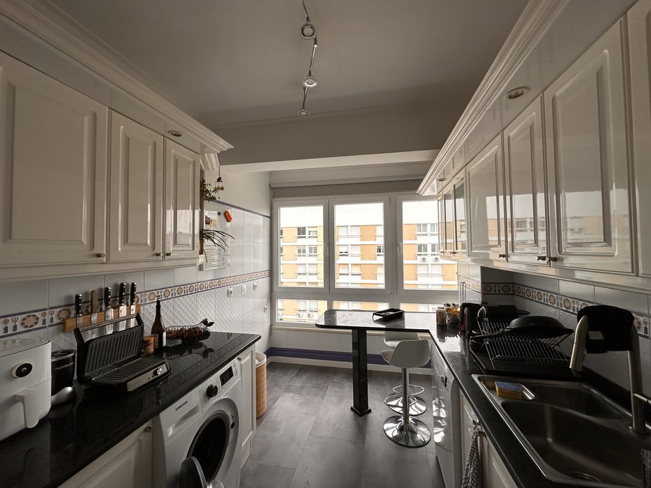 Cozinha em madeira lacada com bancada em granito e península