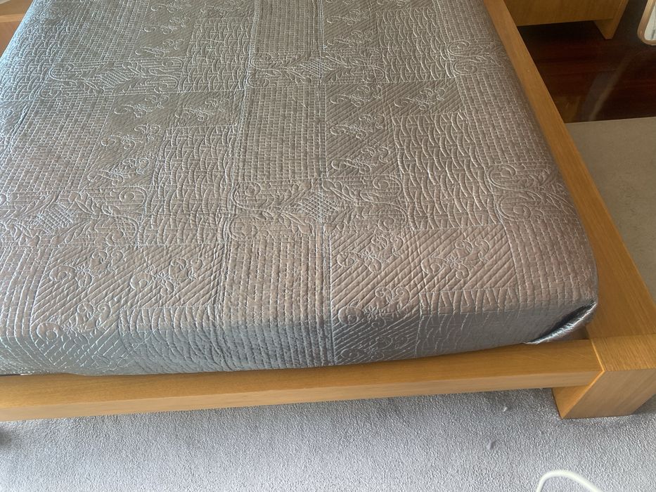 Quarto com cama de casal, colchao e mesinhas de cabeceira