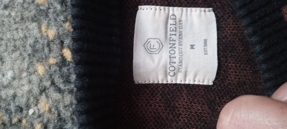 Bordowy sweter w czarną pepitkę.