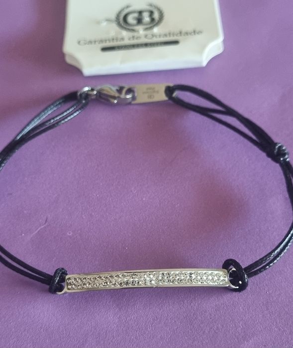 Pulseira preta e prateada, em aço. Chapinha com 2 fiadas de zirconias. Ajustável
