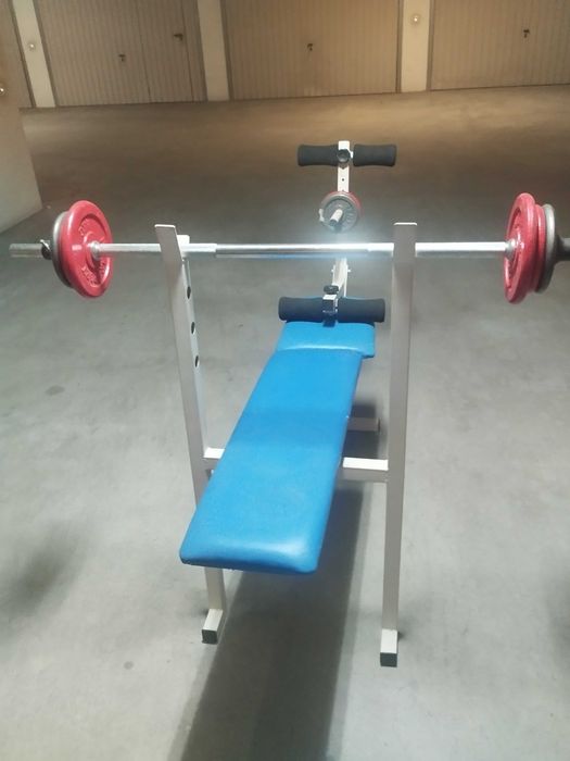Mesa de musculação com alguns pesos