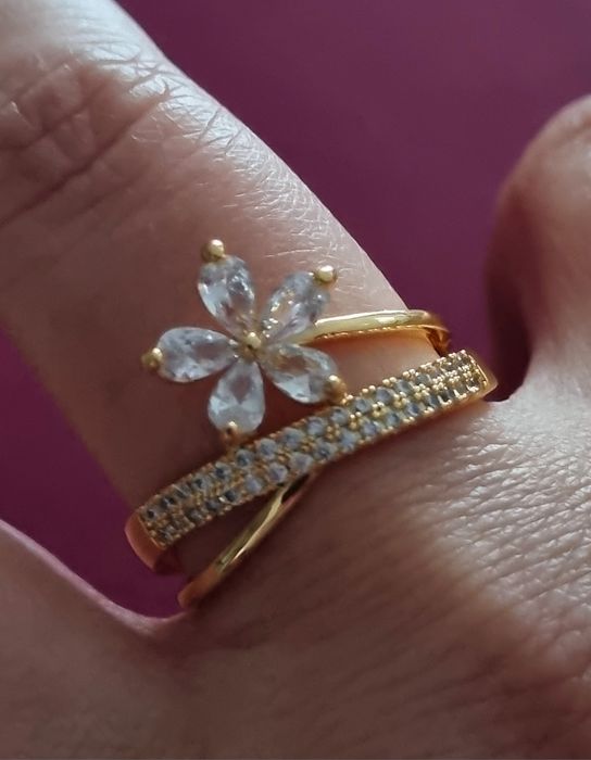Anel dourado, em aço, com zirconias e uma flor. T17 e T20
