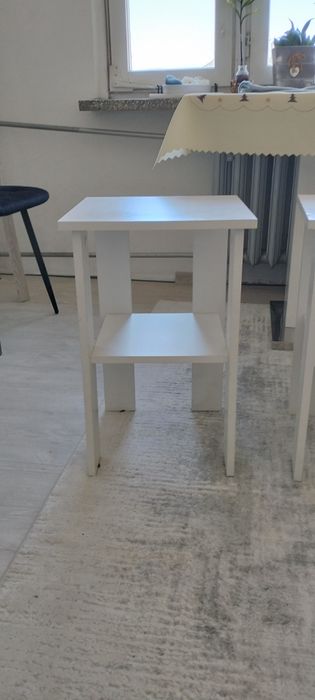 Dwie białe szafki z półką.