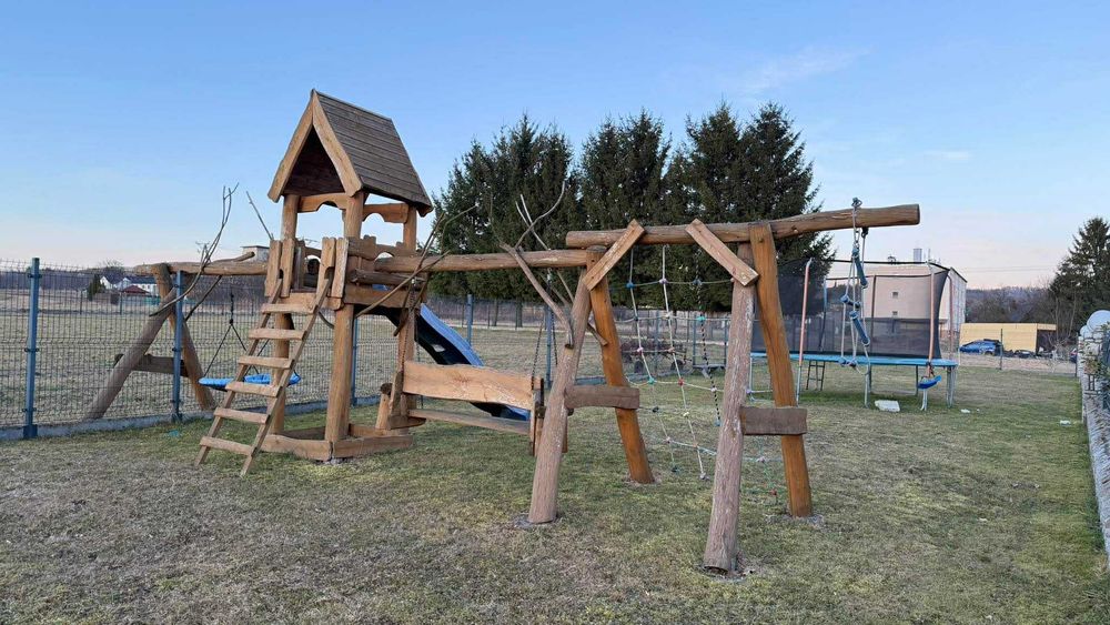 Drewniany plac zabaw z huśtawką i zjeżdżalnią