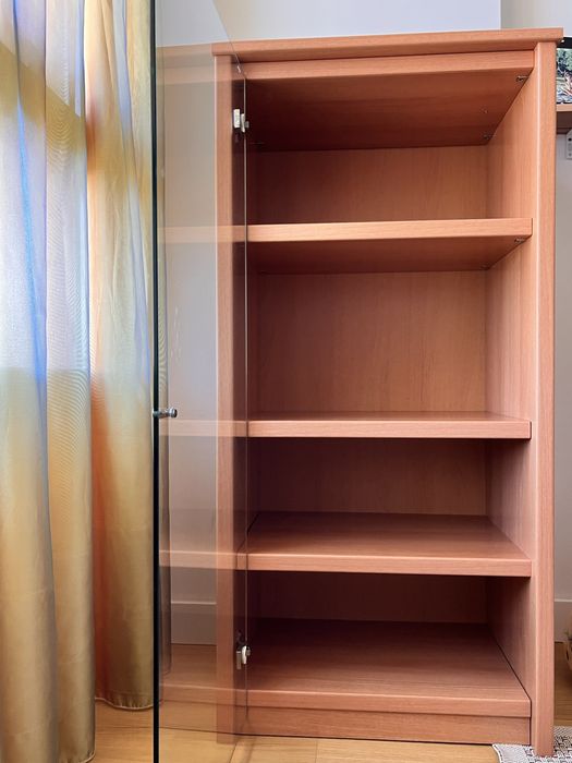 Estante  de madeira carvalho e com porta de vidro.