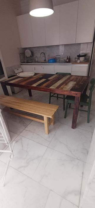 Mesa de jantar/cozinha área antiga com duas cadeiras verdes e banco corrido