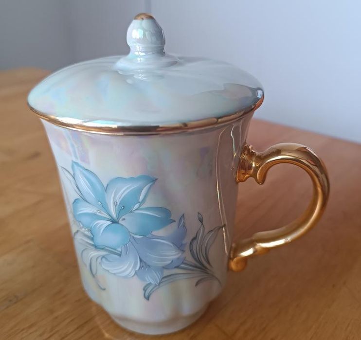 Красива з позолотою та перламутром порцелянова чашка з кришкою на вибі