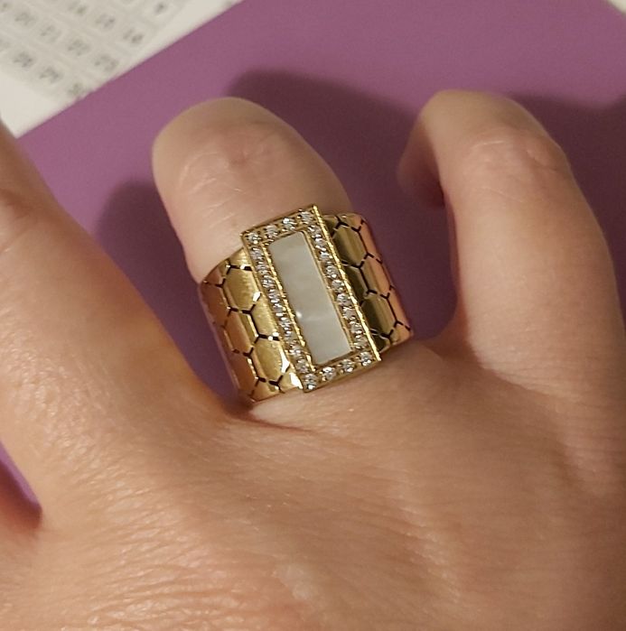 Anel dourado, em aço trabalhado, com uma madrepérola retangular rodeada de zirconias. T18