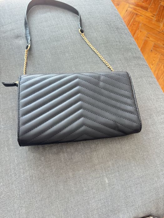 mala preta com detalhes dourados ysl