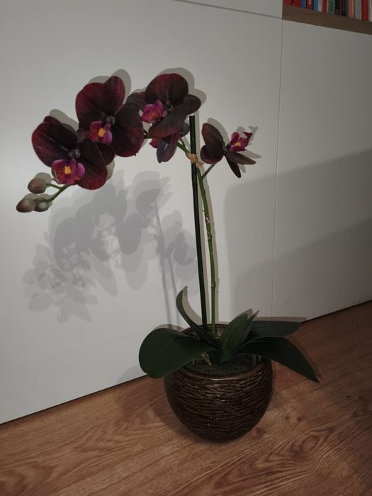 Vaso castanho com orquídea rosa artificial