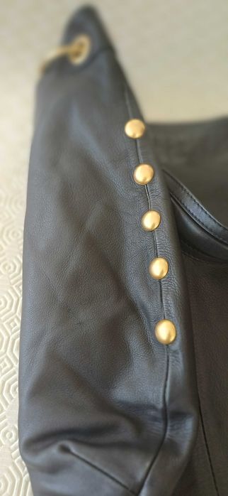 Mala preta em pele com tachas douradas