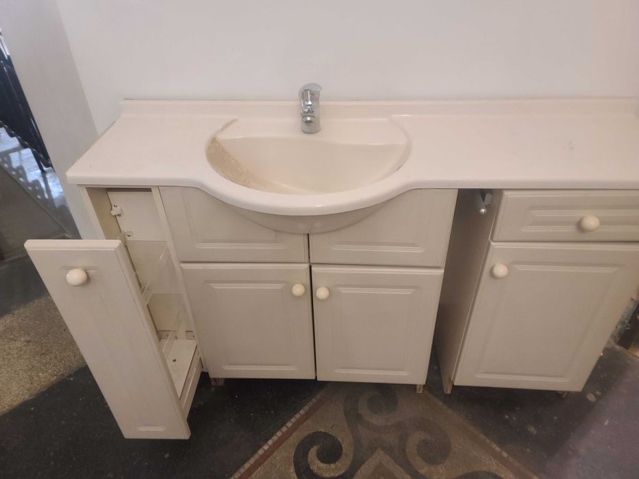 Szafka łazienkowa z umywalka i baterią.