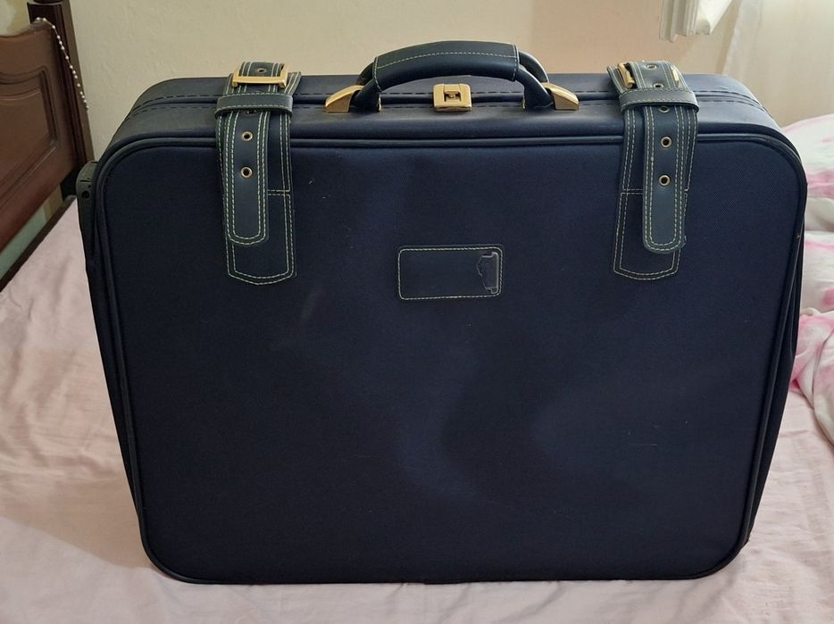 Mala de viagem azul com detalhes dourados