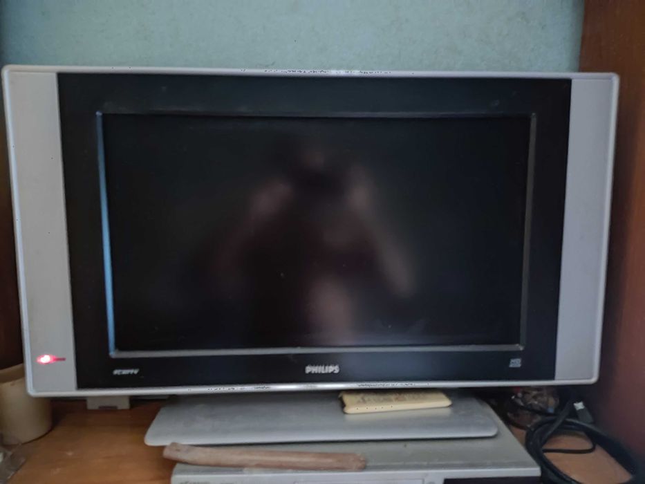 Uma impressora fotocopiadora HP e uma televisão HD Philips.